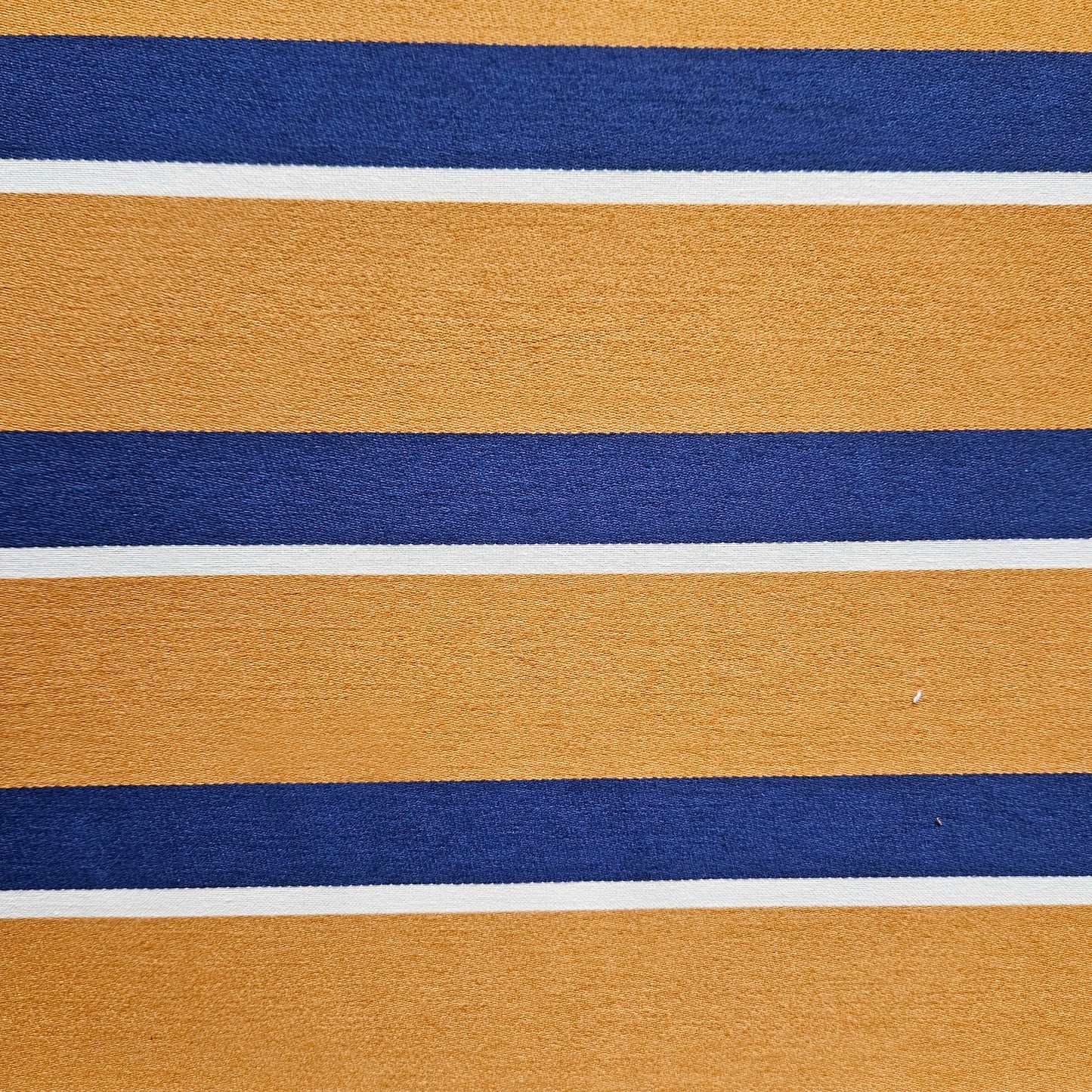 Close-up of fabric with horizontal stripes in gold, blue, and white.