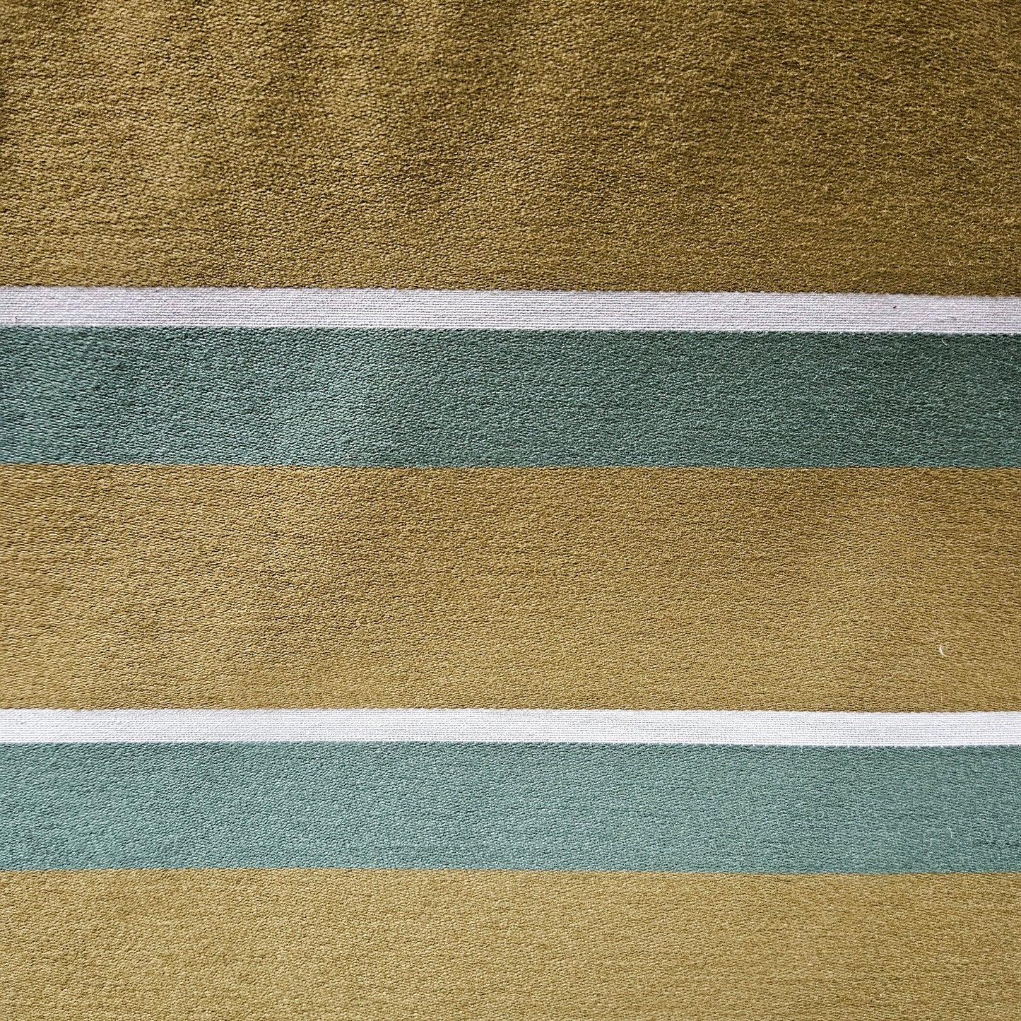 Close-up of fabric with horizontal stripes in green, brown, and white.
