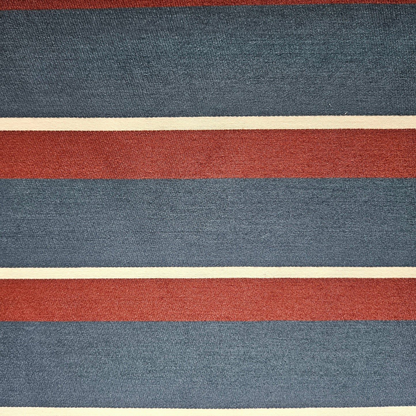 Textured fabric with horizontal stripes in red, blue, and beige.